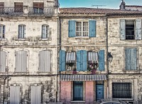 Two old buildings constructed together having wooden and glass windows with flowers. Original public domain image from Wikimedia Commons