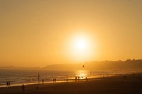 The horizon features the sunset casting yellow color over beach in Bournemouth. Original public domain image from Wikimedia Commons