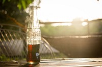 Coca Cola bottle on a table. Original public domain image from Wikimedia Commons