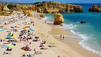 People sunbathing on sandy beach. Original public domain image from Wikimedia Commons