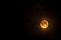 Full lunar eclipse at a dark night sky with a glowing halo around.Original public domain image from Wikimedia Commons