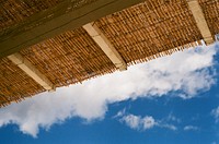 View at the thatched roof with woven rattan and a blue sky at Argostoli. Original public domain image from Wikimedia Commons
