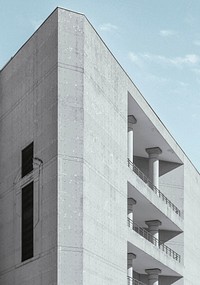 A gray concrete building with columns on its balconies. Original public domain image from Wikimedia Commons