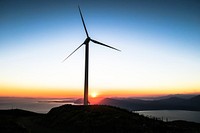 Sun setting below a spinning windmill turbine in Patras. Original public domain image from Wikimedia Commons