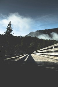 A low shot of a wide wooden bridge leading into a forest in Vorderriss. Original public domain image from <a href="https://commons.wikimedia.org/wiki/File:Wide_wooden_bridge_(Unsplash).jpg" target="_blank" rel="noopener noreferrer nofollow">Wikimedia Commons</a>