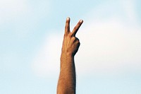 A hand with two fingers raised in a peace sign. Original public domain image from <a href="https://commons.wikimedia.org/wiki/File:Proclaim_peace_(Unsplash).jpg" target="_blank" rel="noopener noreferrer nofollow">Wikimedia Commons</a>