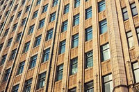 Facade of apartment building in the city with brown exterior and reflective windows in a pattern. Original public domain image from Wikimedia Commons