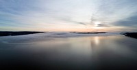 Cloudy sunrise reflects off the sea water in Nesoddtangen, Norway. Original public domain image from Wikimedia Commons