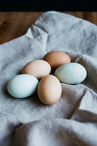 Pastel coloured eggs on a linen towel, ready for Easter. Original public domain image from Wikimedia Commons