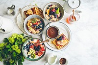 An overhead shot of a waffle, bowls of fruit oatmeal and a cup of coffee. Original public domain image from Wikimedia Commons