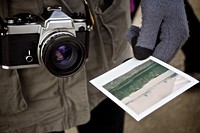 A close-up of a camera and a man wearing gloves holding a photograph.. Original public domain image from <a href="https://commons.wikimedia.org/wiki/File:Man_Camera_Gloves_Photo_(Unsplash).jpg" target="_blank" rel="noopener noreferrer nofollow">Wikimedia Commons</a>