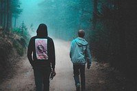 Young friends in graphic hoodies walk through foggy woods. Original public domain image from Wikimedia Commons