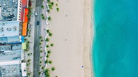 An aerial shot of an empty white sand beach and clear turquoise sea. Original public domain image from Wikimedia Commons