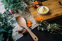 Herbs, turmeric, and spice on cutting board near wooden spoon and paper reading love. Original public domain image from Wikimedia Commons