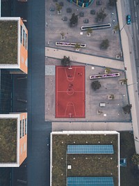 Red basketball court near buildings in aerial. Original public domain image from Wikimedia Commons