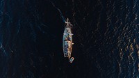 A drone shot of a boat in the ocean. Original public domain image from Wikimedia Commons