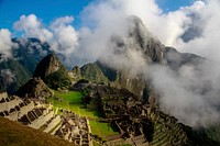 Aerial view of Machu Picchu on a cloudy day. Original public domain image from <a href="https://commons.wikimedia.org/wiki/File:Machu_Picchu_Through_Clouds_(Unsplash).jpg" target="_blank" rel="noopener noreferrer nofollow">Wikimedia Commons</a>