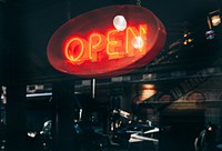 A red neon “open sign” over the storefront in Soho. Original public domain image from Wikimedia Commons