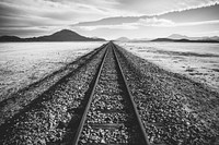 A black-and-white shot of a railway track through a barren wilderness in Bolivia. Original public domain image from <a href="https://commons.wikimedia.org/wiki/File:Railway_track_to_nowhere_(Unsplash).jpg" target="_blank" rel="noopener noreferrer nofollow">Wikimedia Commons</a>