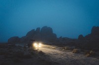 Car lighting the way through rocky terrain in Alabama Hills at dusk. Original public domain image from Wikimedia Commons