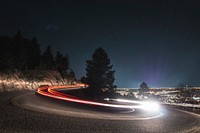 A slow shutter shot of a curved road in Boulder, with fast-driving car light trails. Original public domain image from Wikimedia Commons