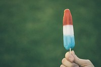 A red, white, and blue rocket popsicle in front a green background. Original public domain image from <a href="https://commons.wikimedia.org/wiki/File:Blue_and_red_popsicle_(Unsplash).jpg" target="_blank" rel="noopener noreferrer nofollow">Wikimedia Commons</a>