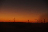 Wind turbine silhouettes at sunset against an orange and red sky in Belgium. Original public domain image from Wikimedia Commons