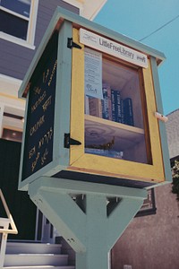 Little Free Library stand with clear door and library books inside and writing on exterior. Original public domain image from <a href="https://commons.wikimedia.org/wiki/File:Little_free_library_stand_(Unsplash).jpg" target="_blank" rel="noopener noreferrer nofollow">Wikimedia Commons</a>