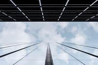 A low-angle shot of a glass facade reflecting the clouds in the sky above. Original public domain image from Wikimedia Commons