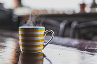 A yellow and white striped mug that is steaming hot in Bucharest. Original public domain image from Wikimedia Commons