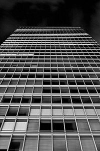 A desaturated shot of a tall office building in Akihabara. Original public domain image from <a href="https://commons.wikimedia.org/wiki/File:No_Title_(Unsplash).jpg" target="_blank" rel="noopener noreferrer nofollow">Wikimedia Commons</a>
