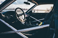 Interior of race car with reinforced door and steering wheel. Original public domain image from <a href="https://commons.wikimedia.org/wiki/File:Race_car_roll_cage_(Unsplash).jpg" target="_blank" rel="noopener noreferrer nofollow">Wikimedia Commons</a>