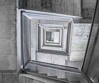 Looking down a gray rectangular stairwell inside. Original public domain image from <a href="https://commons.wikimedia.org/wiki/File:Infinity_(Unsplash_BS1xTOH-eNk).jpg" target="_blank" rel="noopener noreferrer nofollow">Wikimedia Commons</a>
