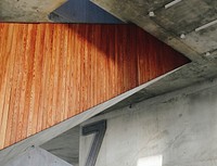 Wooden panelling on the side of a staircase in a building with bare concrete walls. Original public domain image from <a href="https://commons.wikimedia.org/wiki/File:Wooden_staircase_panelling_(Unsplash).jpg" target="_blank" rel="noopener noreferrer nofollow">Wikimedia Commons</a>