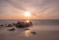 Mist and sunrise over steal ocean make a good view at beach. Original public domain image from Wikimedia Commons