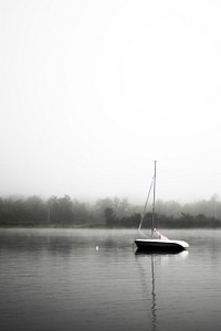 Sailboat sitting on a still lake on a foggy day. Original public domain image from <a href="https://commons.wikimedia.org/wiki/File:Peaceful_Sailboat_Ride_(Unsplash).jpg" target="_blank" rel="noopener noreferrer nofollow">Wikimedia Commons</a>