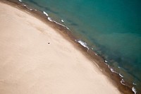 Drone aerial view of a clear water washing on the clean sand shore in Central, Michigan & Delaware. Original public domain image from Wikimedia Commons