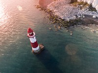 Drone view of the red and white lighthouse by the rocky shoreline at Eastbourne. Original public domain image from Wikimedia Commons