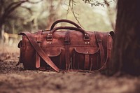 A leather duffel bag on the forest floor under a tree. Original public domain image from <a href="https://commons.wikimedia.org/wiki/File:Leather_duffel_bag_on_the_ground_(Unsplash).jpg" target="_blank" rel="noopener noreferrer nofollow">Wikimedia Commons</a>