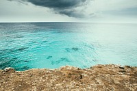 Seascape of the ocean by the rocky coast at Caribbean Netherlands. Original public domain image from <a href="https://commons.wikimedia.org/wiki/File:Ocean_horizon_view_(Unsplash).jpg" target="_blank" rel="noopener noreferrer nofollow">Wikimedia Commons</a>