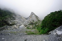 A craggy rock formation with a sharp peak on a mountainside. Original public domain image from Wikimedia Commons
