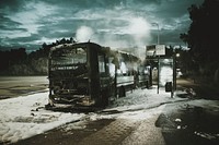 A burnt down bus on a patch of fire fighting foam next to a bus stop. Original public domain image from <a href="https://commons.wikimedia.org/wiki/File:Bus_fire_(Unsplash).jpg" target="_blank" rel="noopener noreferrer nofollow">Wikimedia Commons</a>