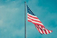 USA flag against blue sky. Original public domain image from <a href="https://commons.wikimedia.org/wiki/File:Anthony_DELANOIX_2015-06-20_(Unsplash_fSnQ8efUCAk).jpg" target="_blank">Wikimedia Commons</a>
