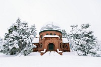 A building in the snow surrounded by wintery trees. Original public domain image from Wikimedia Commons