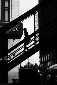 A silhouette shot of a woman walking down a staircase in Chicago.. Original public domain image from Wikimedia Commons