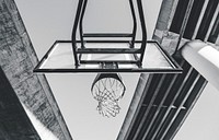 A black and white photo from beneath an outdoor basketball net, on a court under a large overpass bridge. Original public domain image from Wikimedia Commons