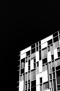 A black-and-white shot of a facade with rectangular windows in various sizes. Original public domain image from <a href="https://commons.wikimedia.org/wiki/File:Black_and_white_rectangles_(Unsplash).jpg" target="_blank" rel="noopener noreferrer nofollow">Wikimedia Commons</a>