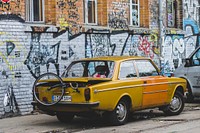 Yellow vintage car parked on the art street. Original public domain image from Wikimedia Commons