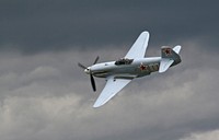 An old propeller plane flying in dark cloudy skies.. Original public domain image from Wikimedia Commons