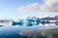A landscape view of an iceberg and its reflection in the water clear blue water. Original public domain image from Wikimedia Commons